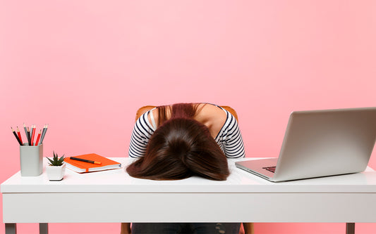  Une femme est assise à un bureau blanc avec sa tête sur la table